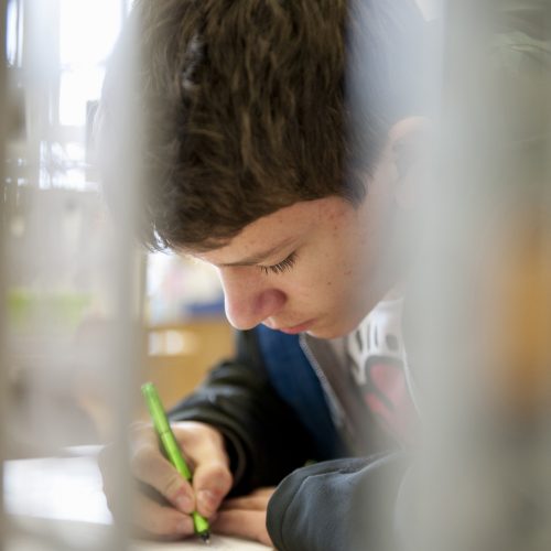 Schreiben ein Schüler schreibt auf ein Aufgabenblatt